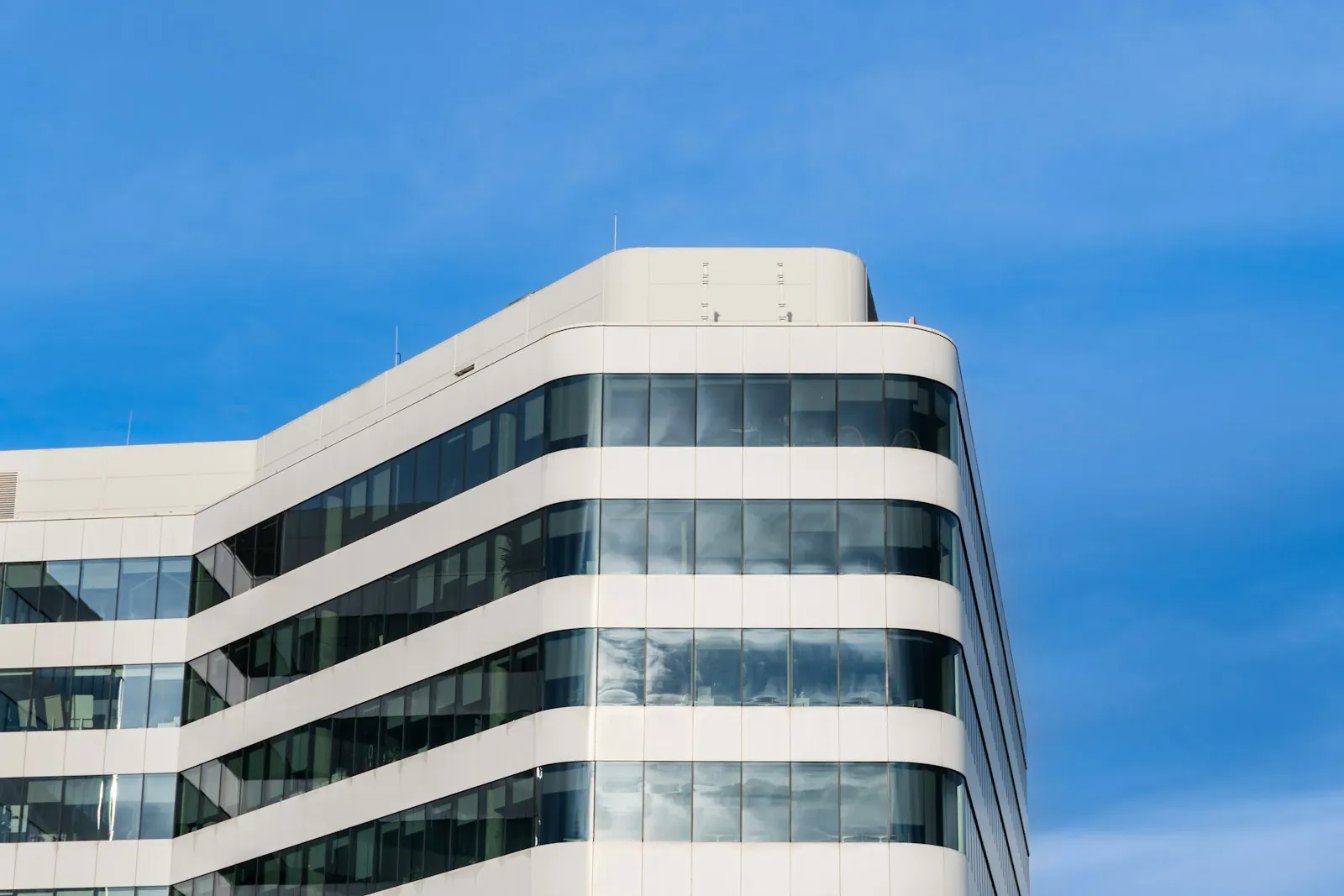 Edificio de oficinas contemporáneo, blanco y de líneas curvas