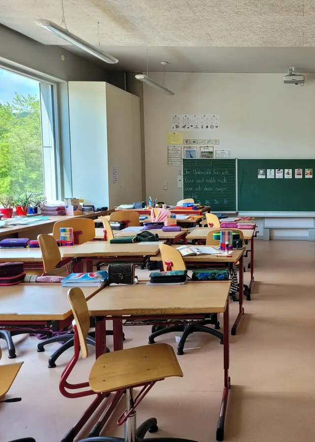 Aula de primaria con pupitres y un gran ventanal